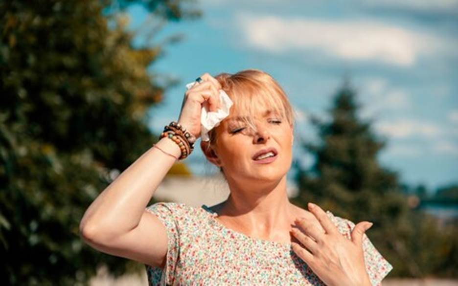 A person wiping her face with a tissue Description automatically generated