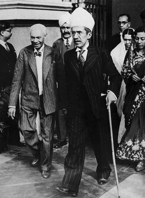 A person in a suit walking with a cane Description automatically generated with low confidence