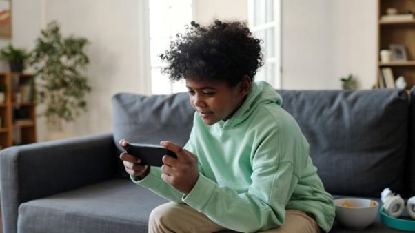 A young person sitting on a couch playing a video game AI-generated content may be incorrect.