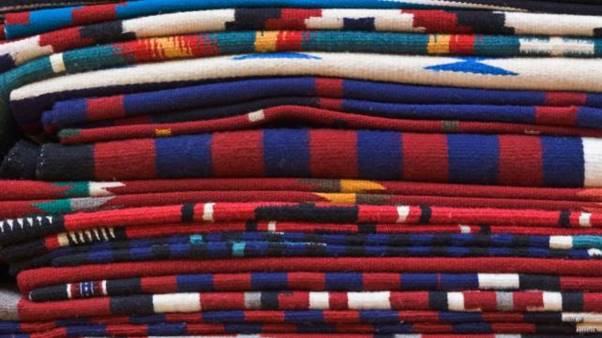 A stack of blankets in different colors AI-generated content may be incorrect.