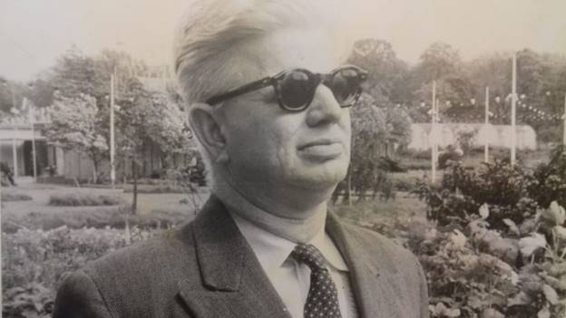 A person wearing sunglasses and a suit AI-generated content may be incorrect.
