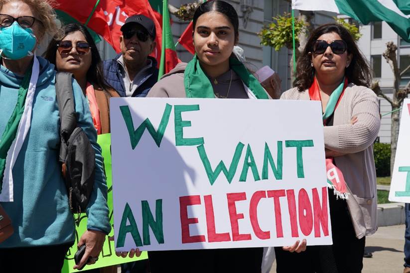 A group of people holding a sign  Description automatically generated