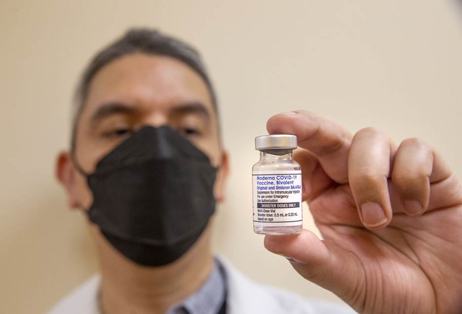 A pharmacist holds a bottle of the Moderna bivalent COVID-19 vaccine booster.