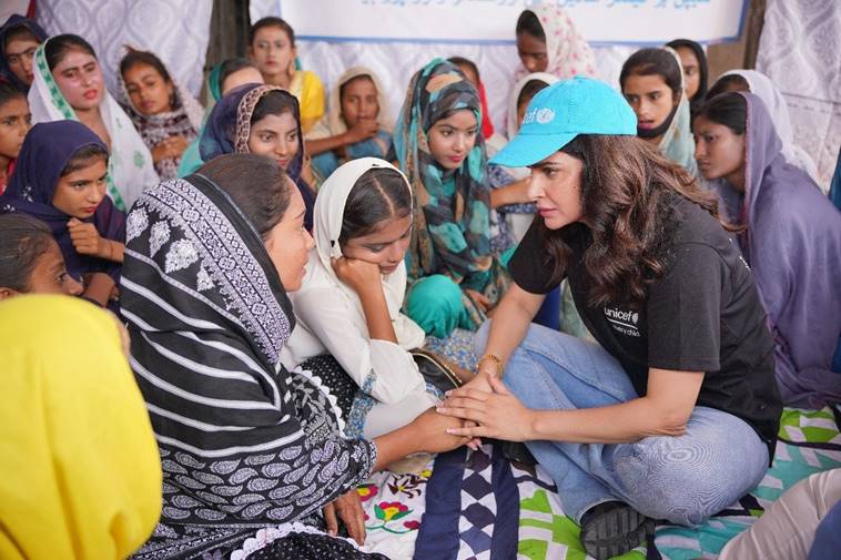 Actor Saba Qamar holds a womans hands as she intently listens to her during an engagement in a rural area. &mdash; Unicef