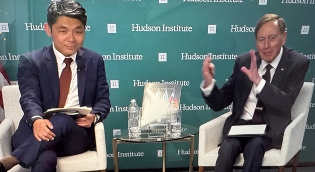 A person in a suit sitting next to a person in a suit AI-generated content may be incorrect.