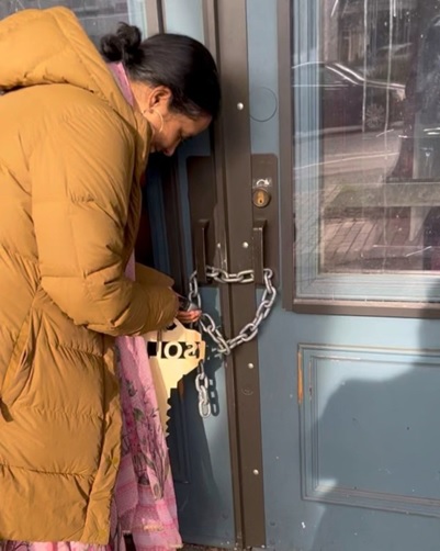 A person in a coat holding a padlock AI-generated content may be incorrect.