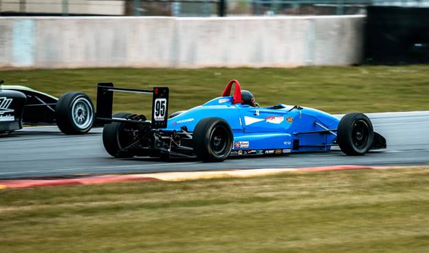 A blue race car on a track AI-generated content may be incorrect.