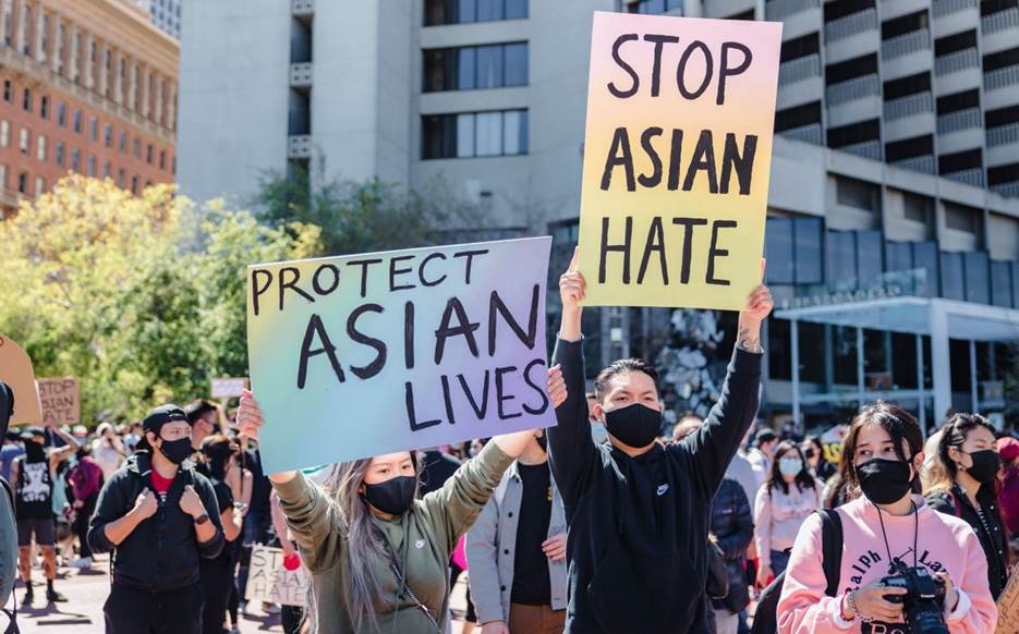 A group of people holding signs  Description automatically generated