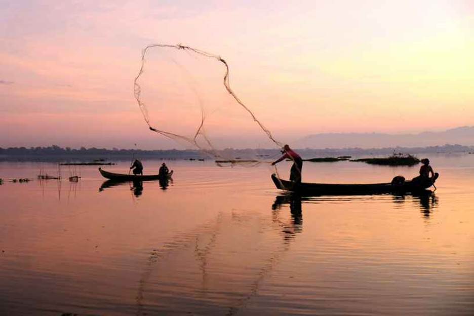 A group of people fishing on a lake  Description automatically generated