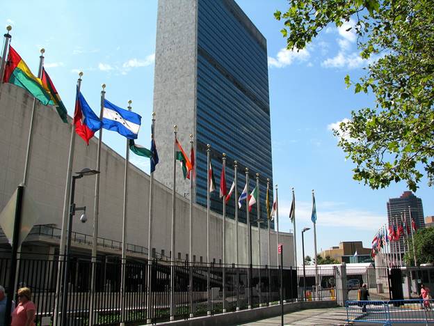 A group of flags in front of Headquarters of the United Nations Description automatically generated