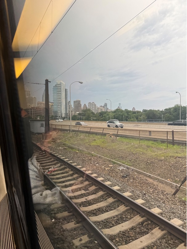 Train tracks with a city in the background AI-generated content may be incorrect.