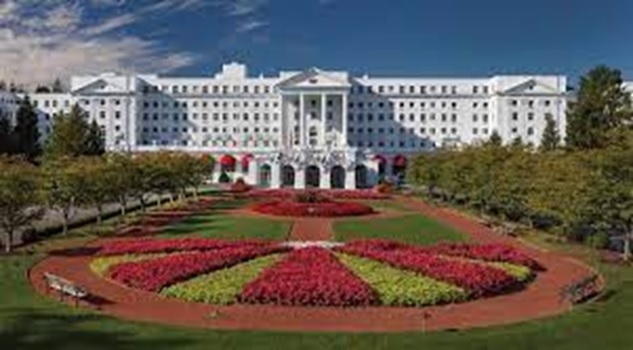 A large white building with a garden with The Greenbrier in the background AI-generated content may be incorrect.