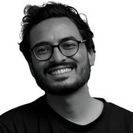 A person wearing glasses smiling AI-generated content may be incorrect.