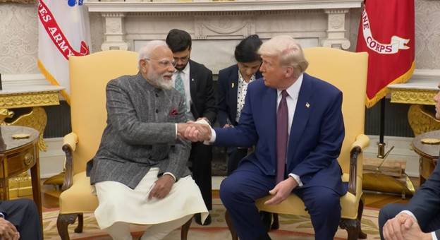 Two men shaking hands in a room AI-generated content may be incorrect.