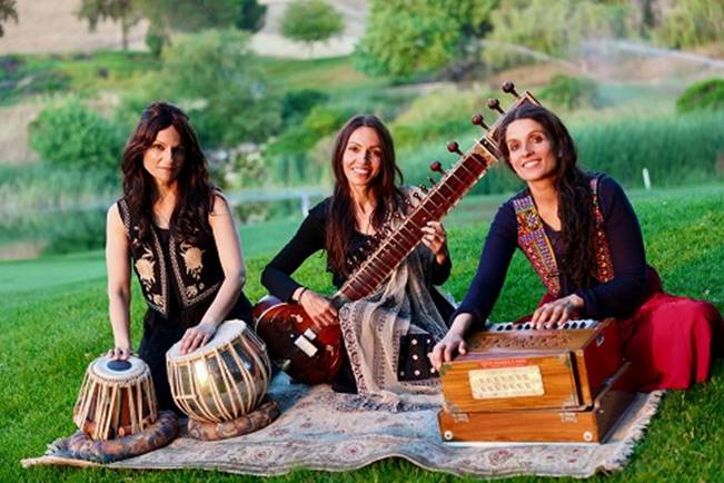 A group of women sitting on a rug playing instruments AI-generated content may be incorrect.