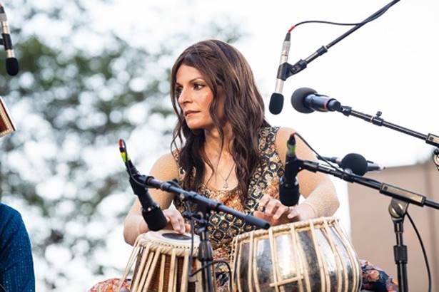 A person playing drums with microphones AI-generated content may be incorrect.